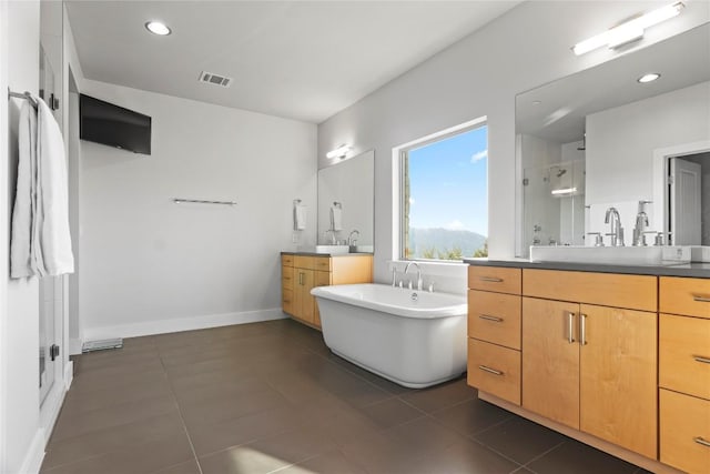 bathroom featuring recessed lighting, two vanities, visible vents, baseboards, and a freestanding bath