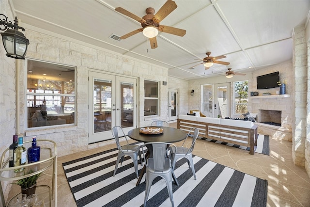 sunroom / solarium featuring visible vents, an outdoor stone fireplace, and french doors