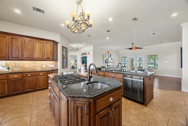 kitchen with a sink, visible vents, open floor plan, stainless steel dishwasher, and an island with sink