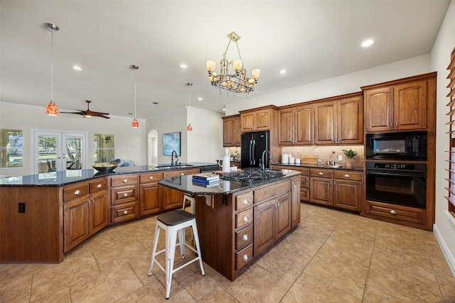 kitchen with brown cabinetry, a spacious island, black appliances, a kitchen bar, and a sink