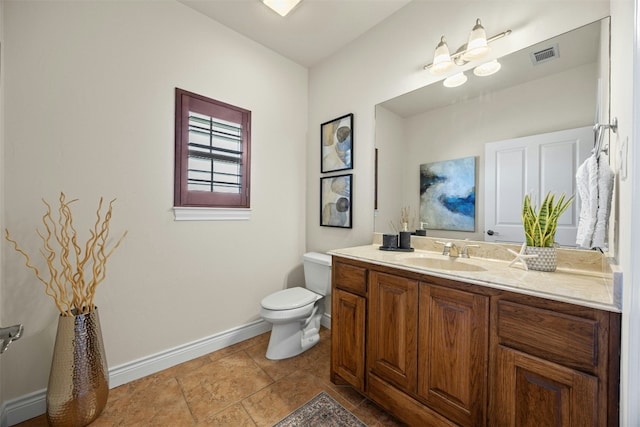 bathroom featuring toilet, vanity, visible vents, baseboards, and tile patterned floors