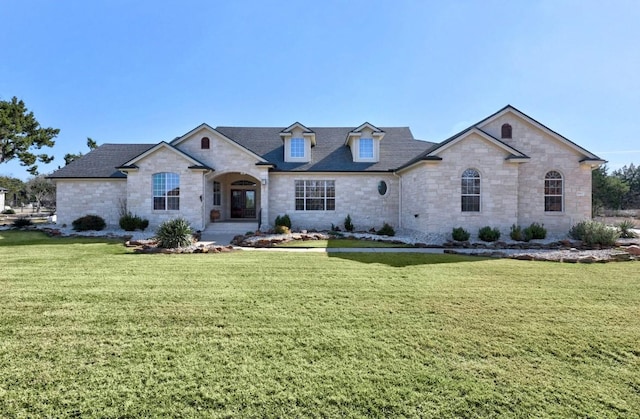 french country inspired facade featuring a front yard