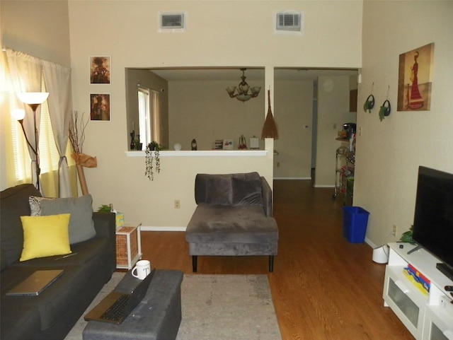 living room featuring wood finished floors, visible vents, and baseboards