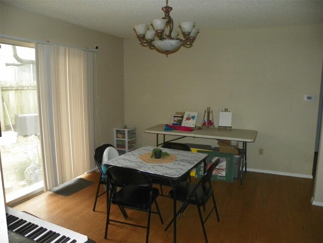 dining space featuring a chandelier, baseboards, and light wood finished floors