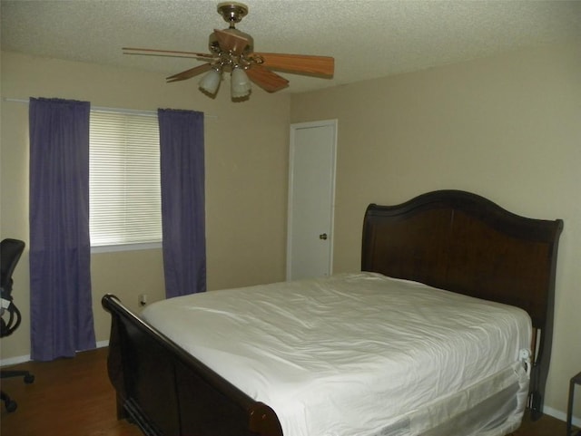 bedroom featuring a textured ceiling, a ceiling fan, and wood finished floors