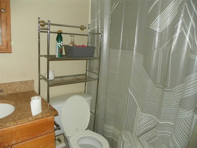 full bath with a shower with curtain, vanity, and toilet