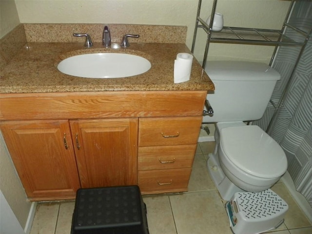 bathroom with toilet, tile patterned flooring, and vanity