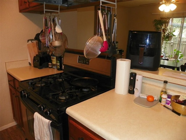 kitchen featuring ceiling fan, light countertops, and gas stove