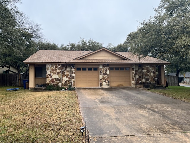 single story home with an attached garage, stone siding, fence, and a front yard