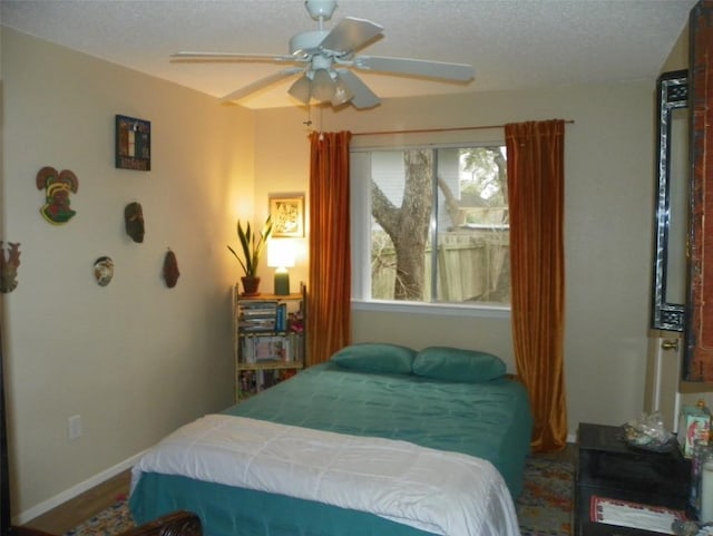 bedroom featuring ceiling fan, baseboards, and a textured ceiling