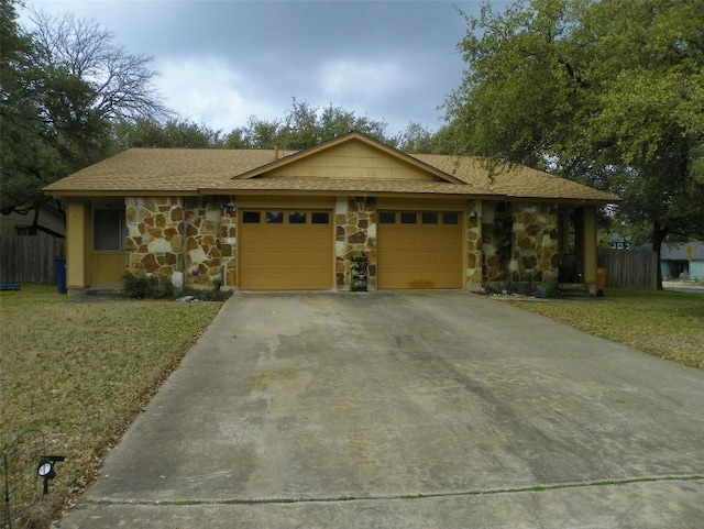 view of front facade with a garage, stone siding, and a front lawn