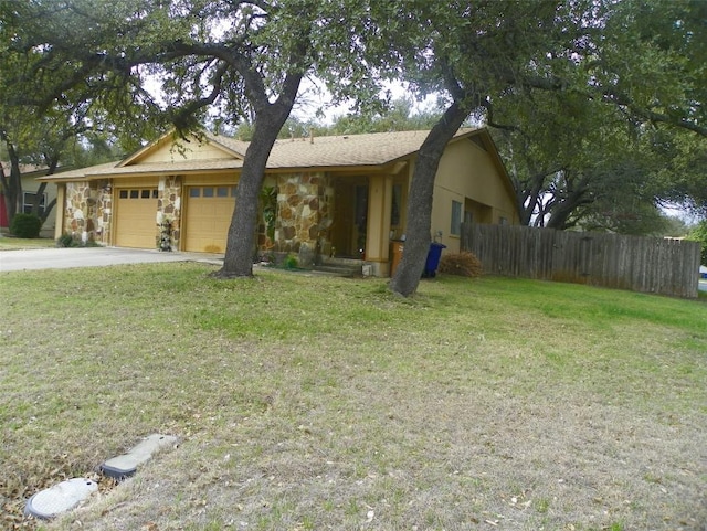 view of front facade featuring stone siding, fence, a front lawn, and an attached garage