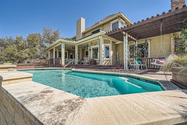 pool with a wooden deck and a pergola