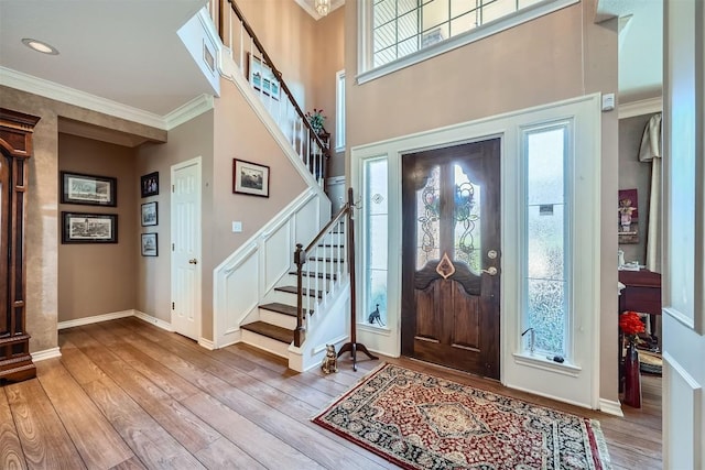 entrance foyer featuring stairway, ornamental molding, and hardwood / wood-style flooring