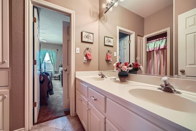 bathroom with tile patterned floors, double vanity, ensuite bathroom, and a sink