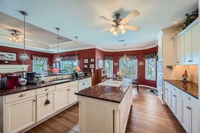 kitchen featuring decorative light fixtures, white cabinets, white appliances, and dark wood-style flooring