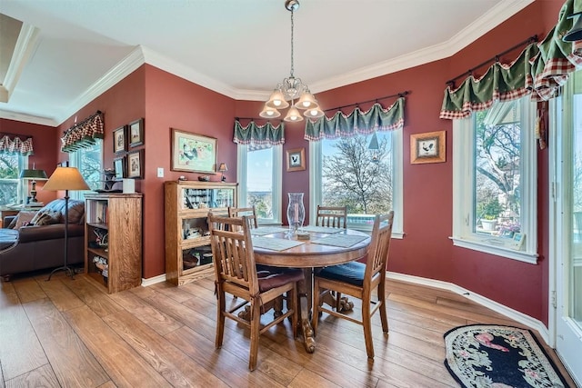 dining room with crown molding, light wood-style flooring, baseboards, and a chandelier