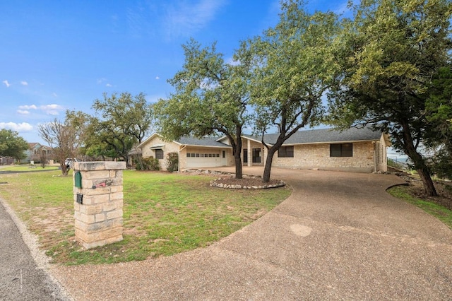 ranch-style home with a front yard, concrete driveway, and brick siding