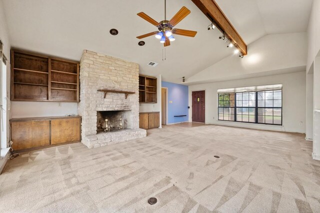 unfurnished living room with high vaulted ceiling, a stone fireplace, light carpet, visible vents, and beam ceiling