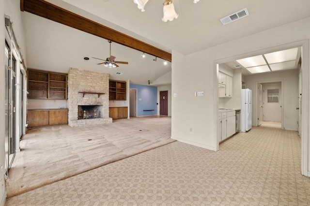 unfurnished living room featuring baseboards, visible vents, a ceiling fan, vaulted ceiling with beams, and a fireplace