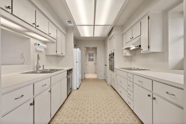 kitchen with under cabinet range hood, a sink, visible vents, white cabinetry, and appliances with stainless steel finishes