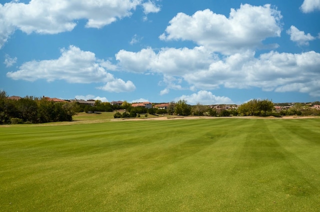 surrounding community featuring view of golf course and a lawn