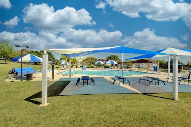 view of community featuring a pool, a patio, and a yard