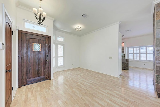 foyer featuring light wood finished floors, visible vents, an inviting chandelier, and ornamental molding