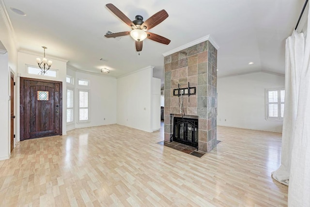 unfurnished living room with ornamental molding, lofted ceiling, a fireplace, and wood finished floors