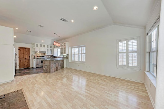 kitchen featuring visible vents, white cabinets, appliances with stainless steel finishes, vaulted ceiling, and light wood-style floors