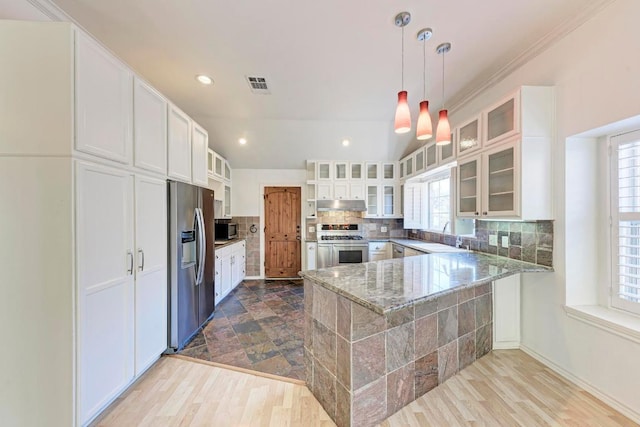 kitchen with stainless steel appliances, tasteful backsplash, visible vents, a peninsula, and under cabinet range hood