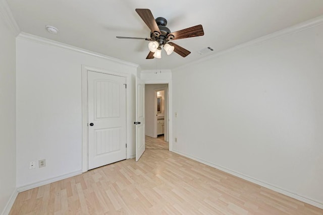 interior space with light wood finished floors, ornamental molding, visible vents, and baseboards