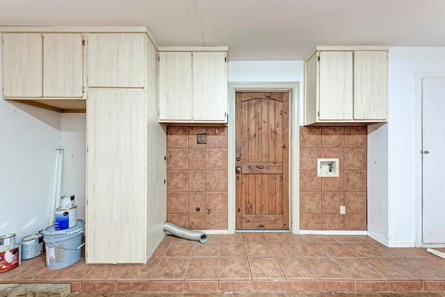 kitchen featuring light tile patterned floors, cream cabinetry, and tile walls