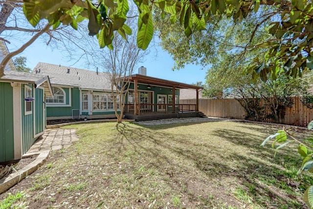 back of property with fence private yard, a chimney, a deck, and a lawn