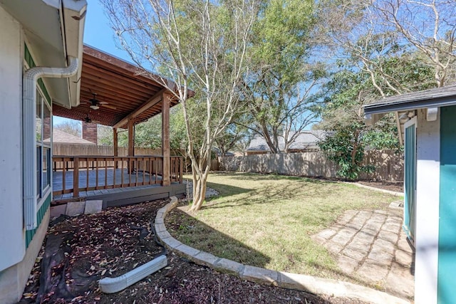 view of yard featuring a fenced backyard, ceiling fan, and a wooden deck