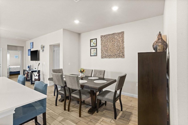 dining space with light wood-type flooring, baseboards, and recessed lighting