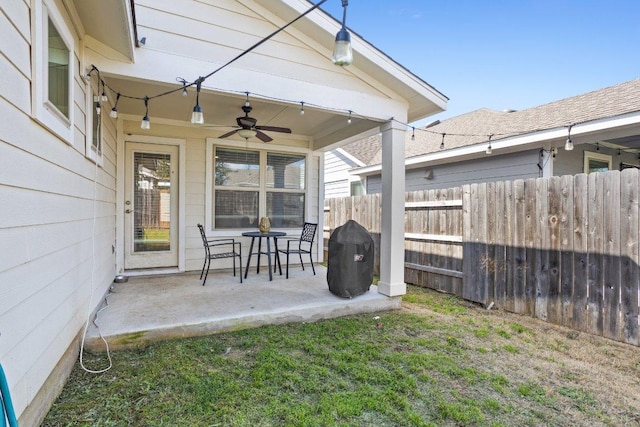 view of patio with ceiling fan and fence