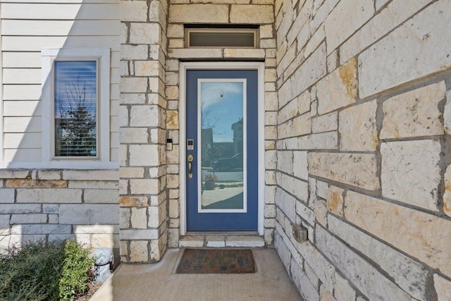 property entrance featuring stone siding