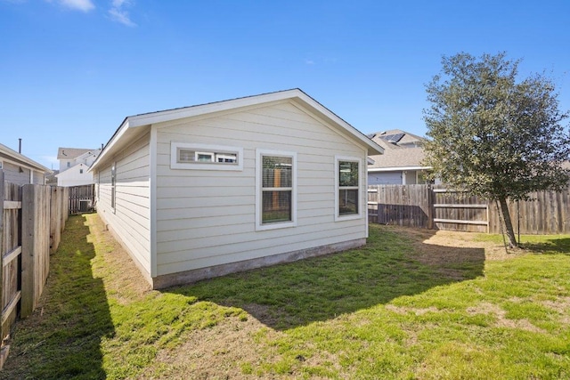 back of property with a fenced backyard and a yard