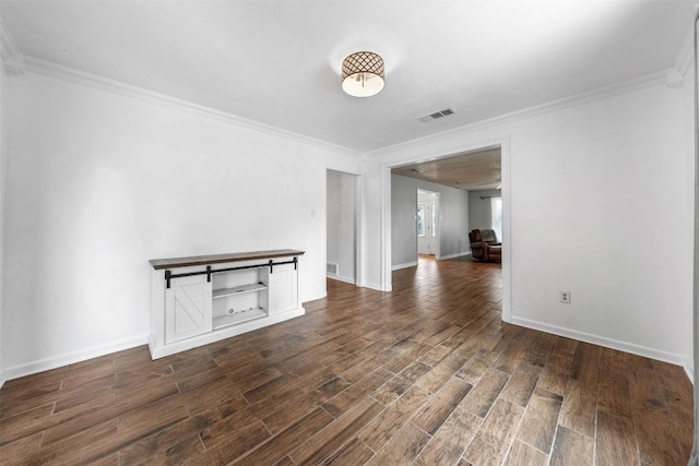 spare room with dark wood-type flooring, visible vents, and ornamental molding