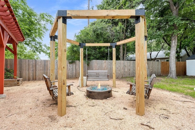 view of playground with an outdoor fire pit and a fenced backyard