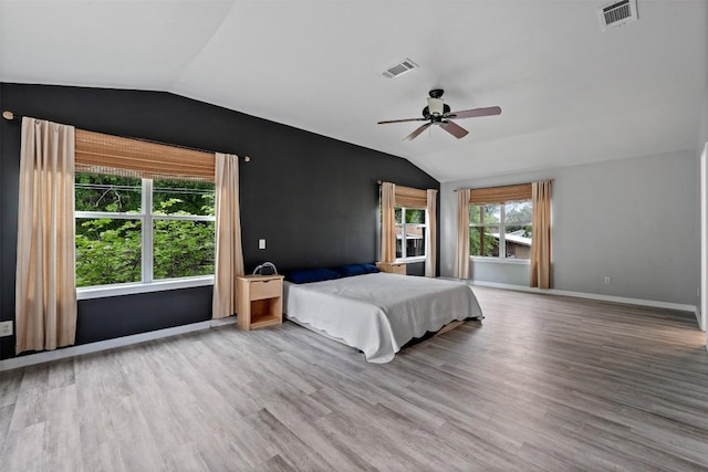 unfurnished bedroom with vaulted ceiling, wood finished floors, and visible vents