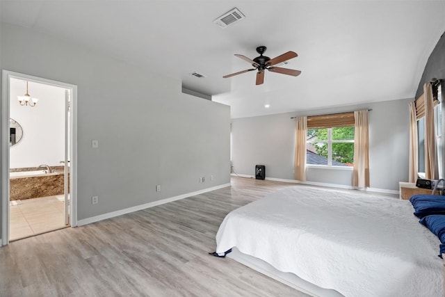 bedroom featuring baseboards, visible vents, wood finished floors, and ensuite bathroom