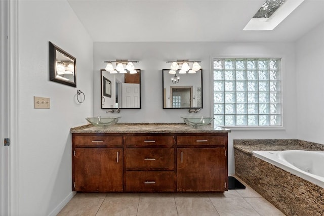 full bathroom with a wealth of natural light, a skylight, a sink, and tile patterned floors