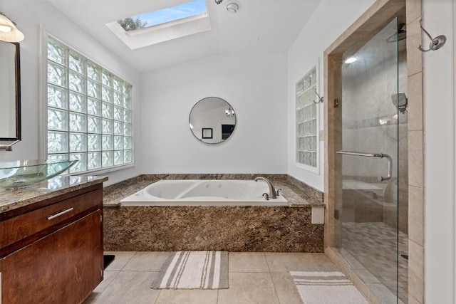 full bath with a skylight, a stall shower, a garden tub, tile patterned flooring, and vanity