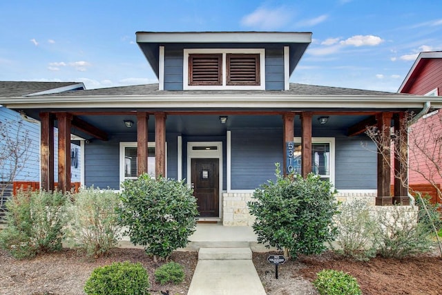 bungalow-style house featuring covered porch and a shingled roof