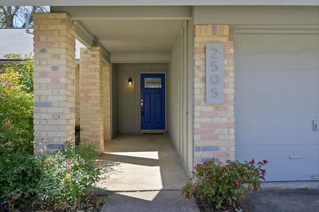 view of exterior entry featuring brick siding