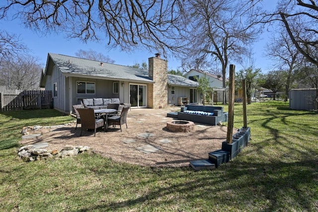 rear view of house featuring a lawn, an outdoor living space with a fire pit, a chimney, fence, and a patio area