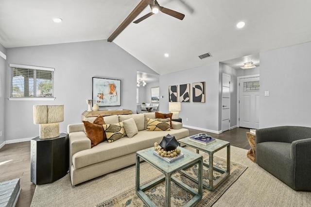 living area featuring visible vents, lofted ceiling with beams, baseboards, and wood finished floors