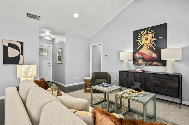 living area featuring vaulted ceiling, wood finished floors, visible vents, and baseboards